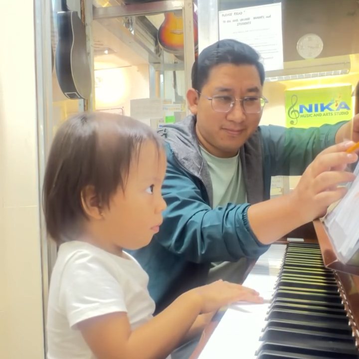 Young student learning piano with a NIKA teacher